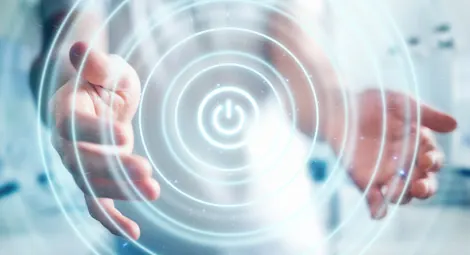 Des mains entourent un symbole de mise sous tension et des ondes concentriques